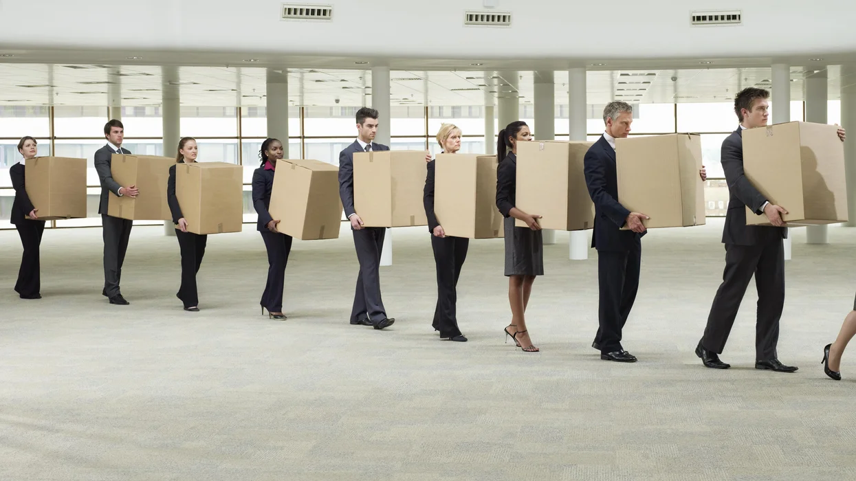 a-line-of-people-in-businesswear-carrying-boxes